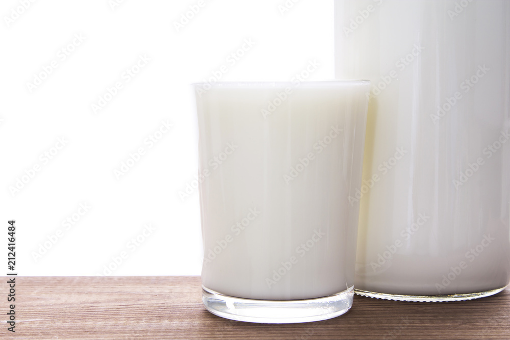 bottle with milk and glass of milk on wooden table