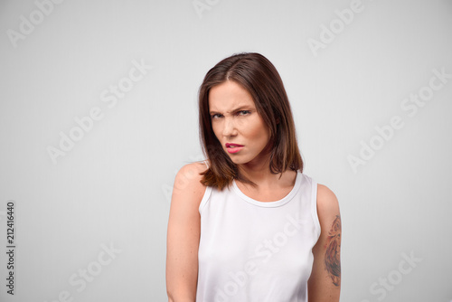 Young woman with disgusted expression repulsing something. Disgust concept. Young emotional woman. Human emotions, facial expression concept. Studio. Isolated. © EverGrump