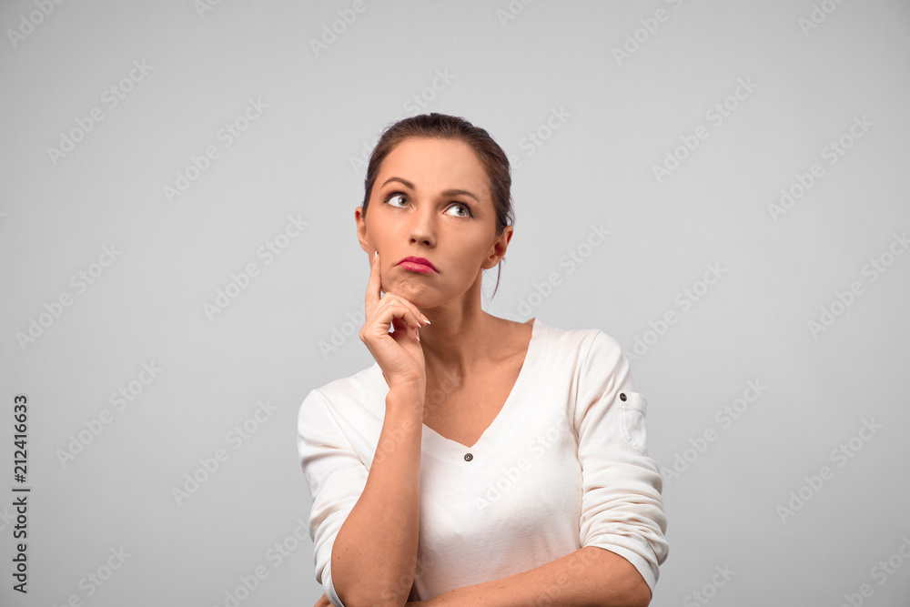 Young attractive brunette female student dressed casually, has thoughtful expression as thinks over her future actions and plans in life, going to graduate and find successful job. Young attractive brunette female student dressed casually, has thoughtful expression as thinks over her future actions and plans in life, going to graduate and find successful job.