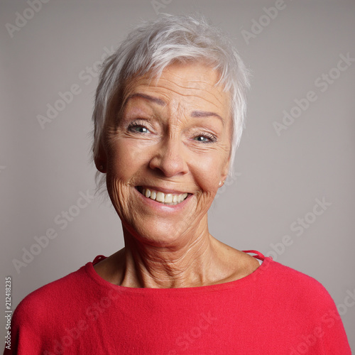 happy older woman in her 60s with trendy short white hair laughing