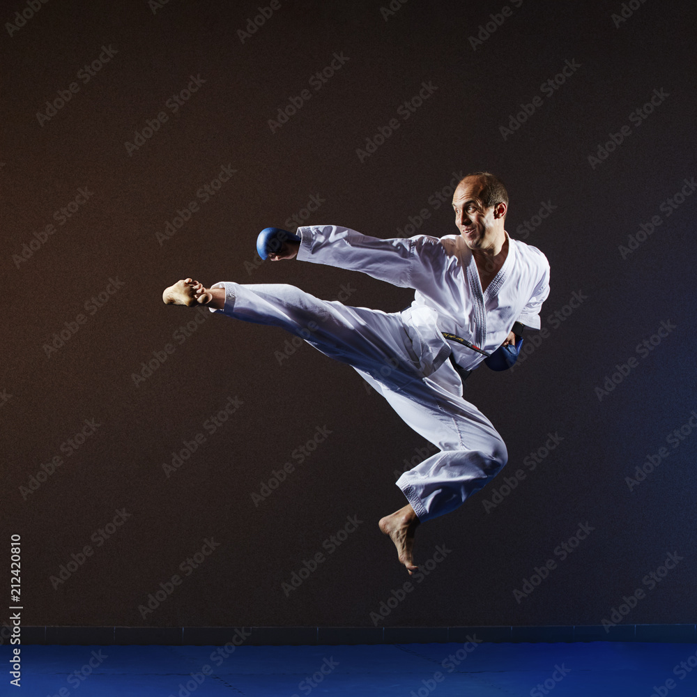 In a high jump athlete in karategi beats kick leg