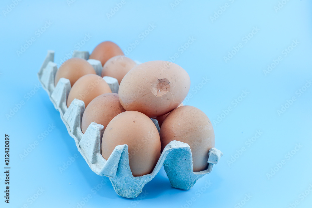 Broken Eggs in paper tray isolated on a blue background. Broken Eggs in paper tray isolated on a blue background.