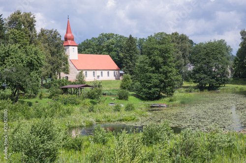 Lake and old church. Blue sky and green grass. photo