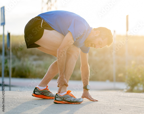 Papier peint Runner touching painful twisted or broken ankle.