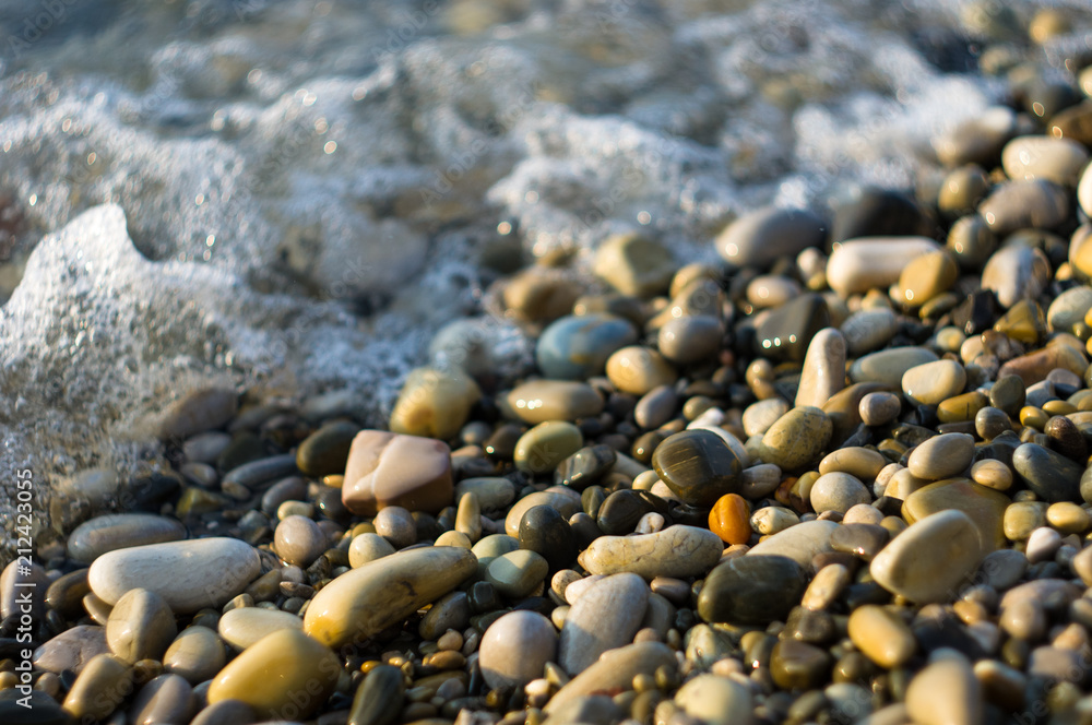 pebble stones on the sea beach, the rolling waves of the sea with foam pebble stones on the sea beach, the rolling waves of the sea with foam