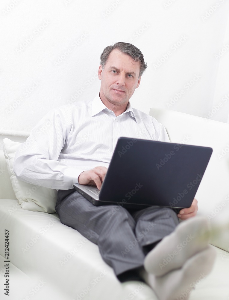 businessman working on laptop while sitting in a hotel room businessman working on laptop while sitting in a hotel room