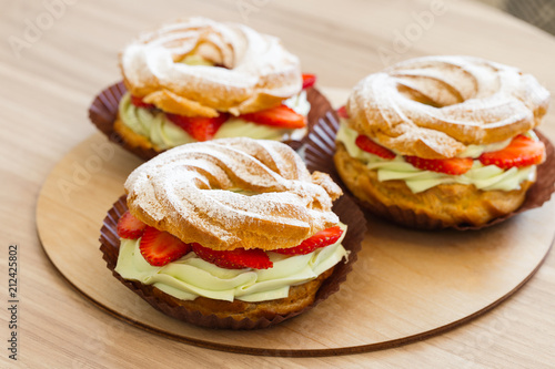 Paris Brest, Cream puff rings with pistachio cream and fresh strawberry, traditional french choux pastry