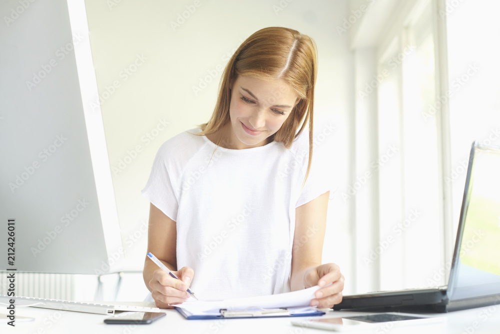 Confident young businesswoman working at office desk. Home office Confident young businesswoman working at office desk. Home office