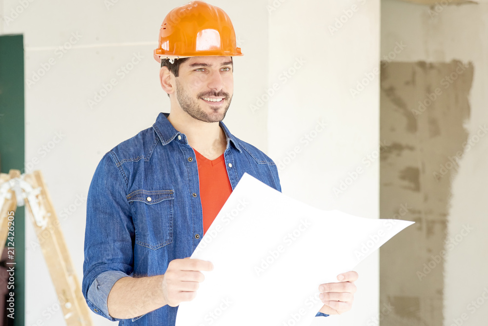 Young engineer with blueprint at construction site Young engineer with blueprint at construction site