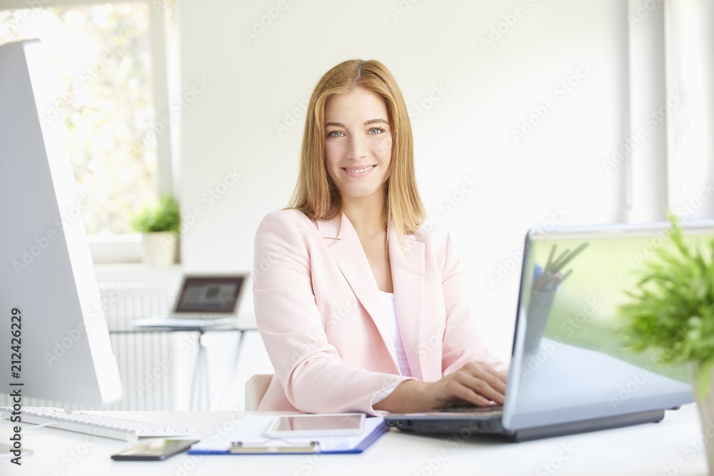Young professional woman using laptop while working at home office Young professional woman using laptop while working at home office