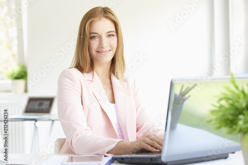 Young professional woman using laptop while working at home office