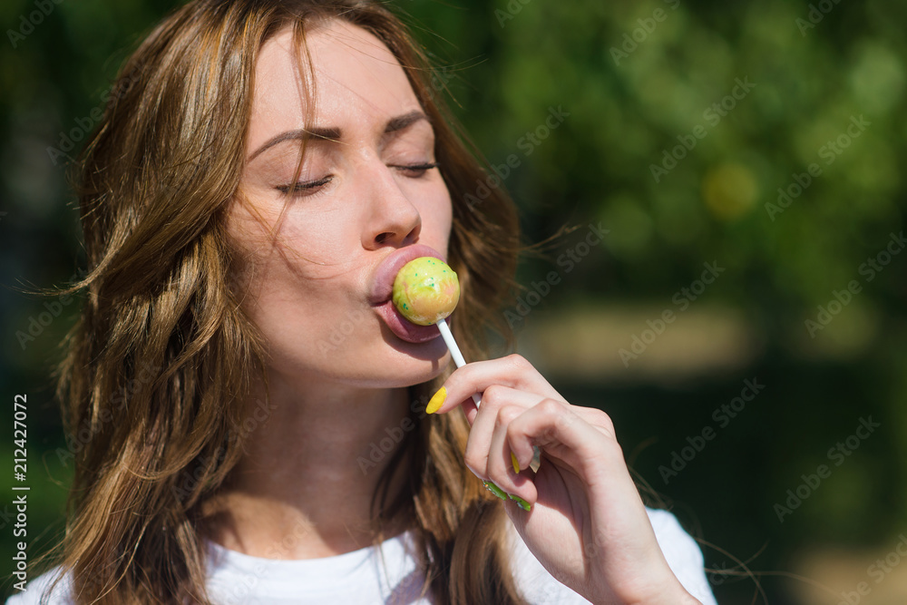 Beautiful girl sucks Lollipop in summer outdoors Beautiful girl sucks Lollipop in summer outdoors