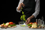 The chef prepares a salad, frozen lettuce leaves, on a dark background with an empty space for writing