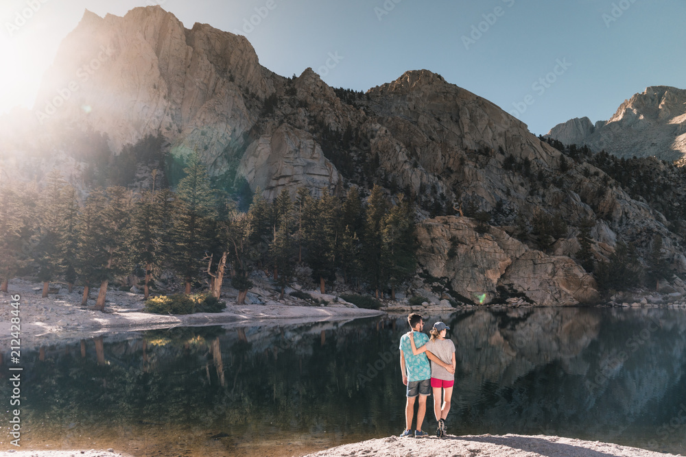 young couple in  Yosemite, USA: Mountain landscape with mirror lake surrounded by high peaks