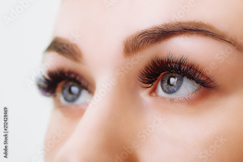 Eyelash Extension Procedure. Woman Eye with Long Eyelashes. Close up, selective focus.