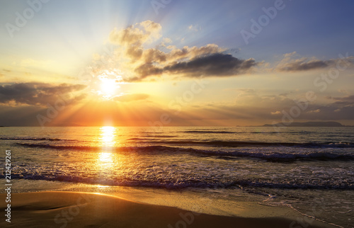 Golden sunrise sunset over the sea ocean waves. Rich in dark clouds, rays of light
