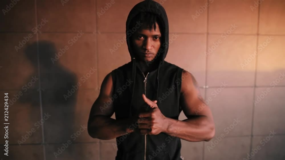 Rapper man serious hooligan gangster in urban place looking at me Rapper man serious hooligan gangster in urban place looking at me
