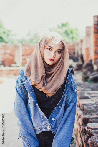 Fashion portrait of young beautiful muslim woman and old town background.