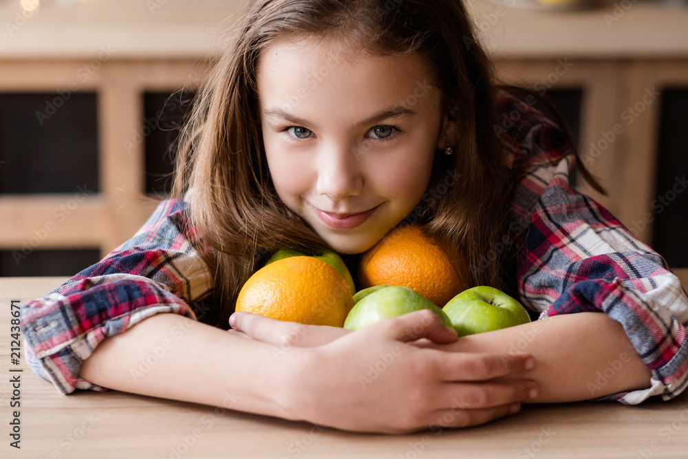 Fototapeta premium healthy fruit snacks for kids. wholesome diet and natural organic food for children development. girl holding a mix of oranges and apples in hands