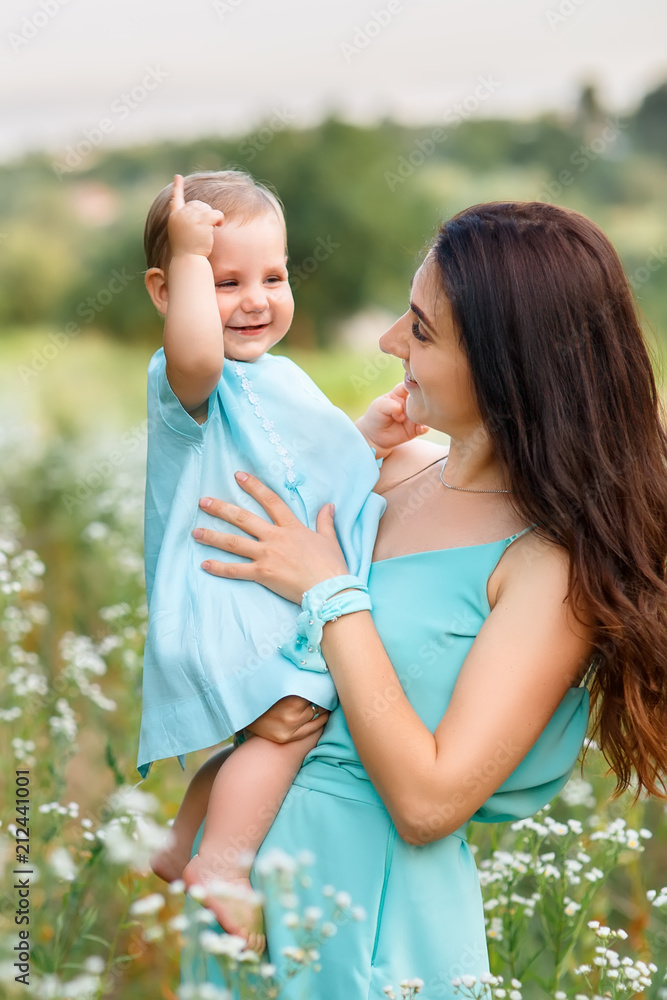 mother holding little daughter on summer meadow mother holding little daughter on summer meadow