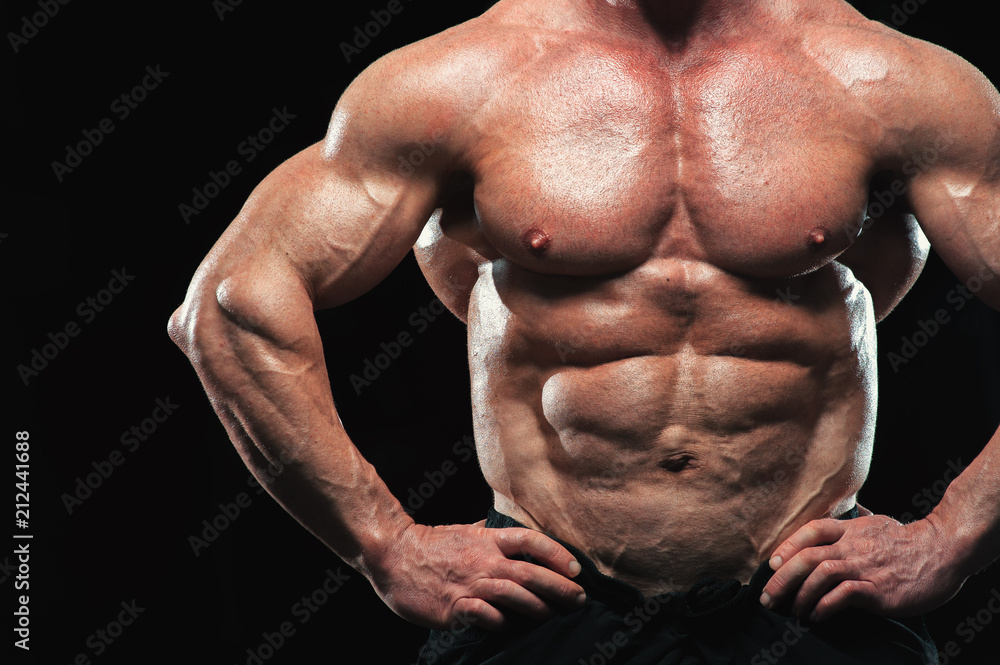 Close-up - Male fitness model with naked torso showing sixpack abdominal and muscular body.