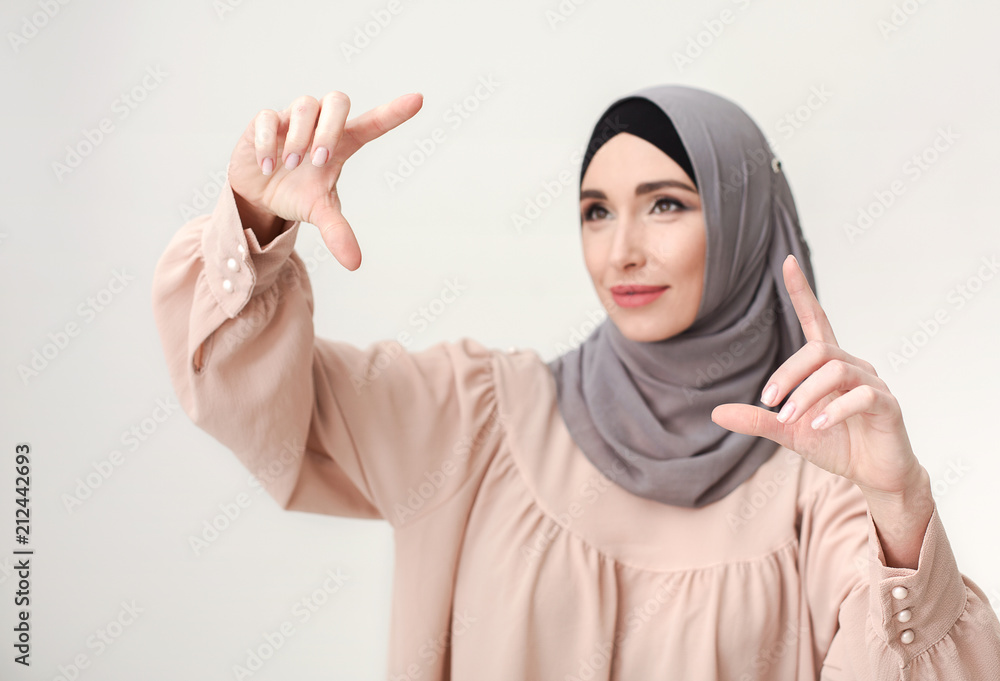 Muslim woman pointing on virtual screen, copy space Muslim woman pointing on virtual screen, copy space