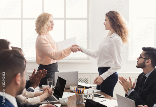 Boss handshaking employee congratulating with promotion