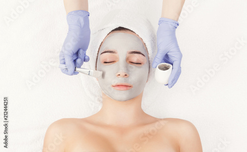 Woman gets face mask by beautician at spa