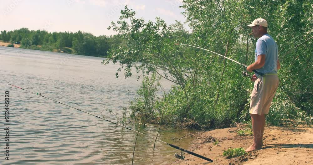 Happy father and son are fishing, the son helps his father pull out the caught fish, carries the fish catcher. Happy family. Happy father and son are fishing, the son helps his father pull out the caught fish, carries the fish catcher. Happy family.