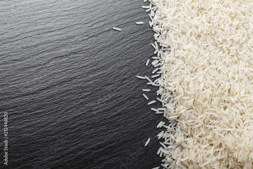 raw rice scattered on a black background