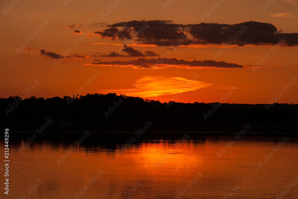 A beautiful summer landscape of the orange sunset over the river, Ukraine. Concept - the beauty of the planet Earth.