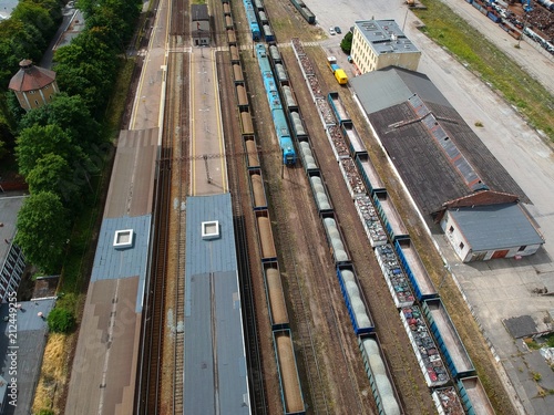 Cargo and passenger wagons on train station in city, aerial view