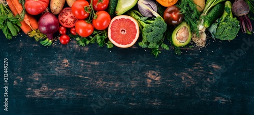 Healthy food. Vegetables and fruits. On a black wooden background. Top view. Copy space.