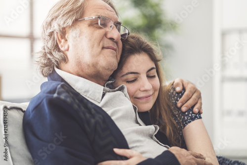 Fototapeta Young daughter hugs her father