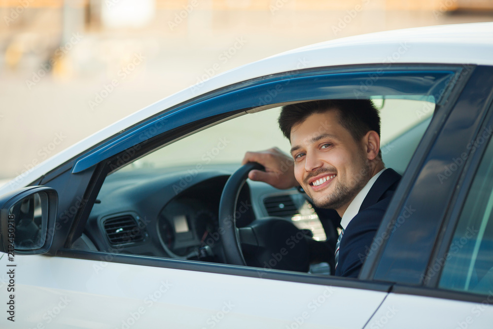 handsome young man in suit sitting in car in summer handsome young man in suit sitting in car in summer