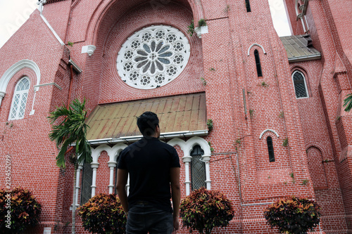 Behind of the man standing in front of the main building of church and church tower at cathedral of the holy trinity, the church of the province of Myanmar. photo