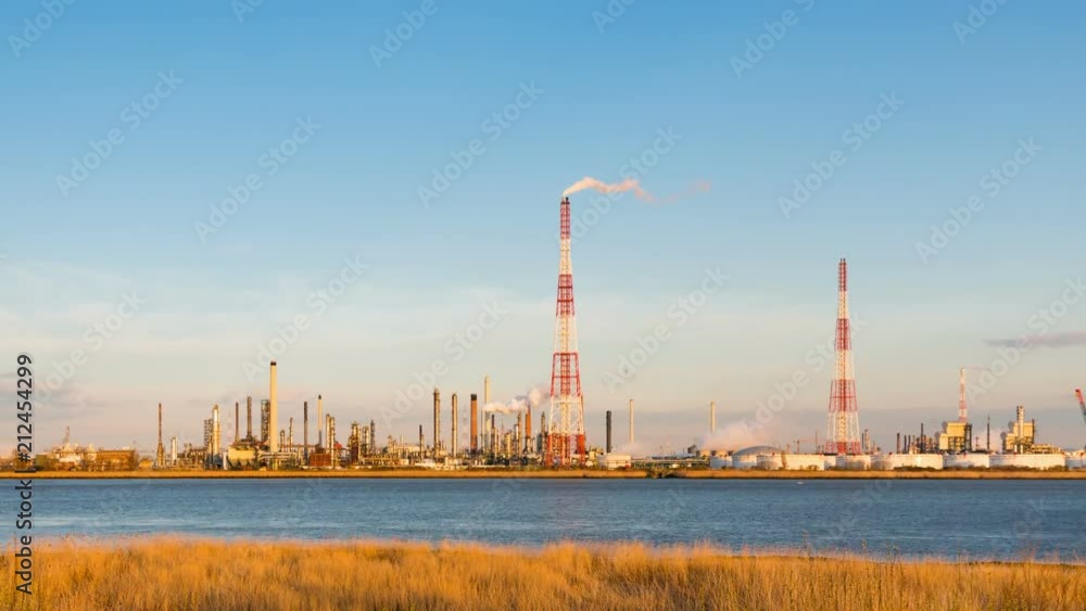 Timelapse sequence of a large oil refinery in the harbor of Antwerp, Belgium with blue sky and warm evening light, zooming in. Timelapse sequence of a large oil refinery in the harbor of Antwerp, Belgium with blue sky and warm evening light, zooming in.