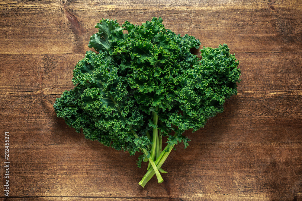 Raw organic freshly picked green curly kale on wooden table Raw organic freshly picked green curly kale on wooden table