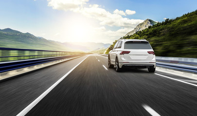 Fotobehang Snelle auto Witte auto op zonnige snelweg  © Denis Rozhnovsky
