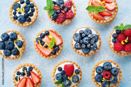 Berry tartlets background. Delicious summer pastry dessert top view.