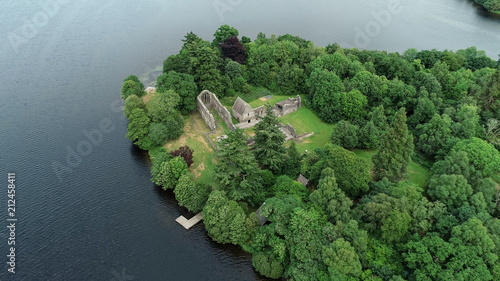 Aerial image of the ruins of Inchmahome Priory on a tree covered island on the picturesque Lake of Menteith. photo