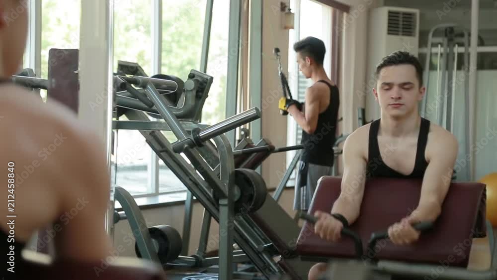 Man lift weights at the gym.Young man in the gym.Young man in the gym, exercise for the biceps Man lift weights at the gym.Young man in the gym.Young man in the gym, exercise for the biceps