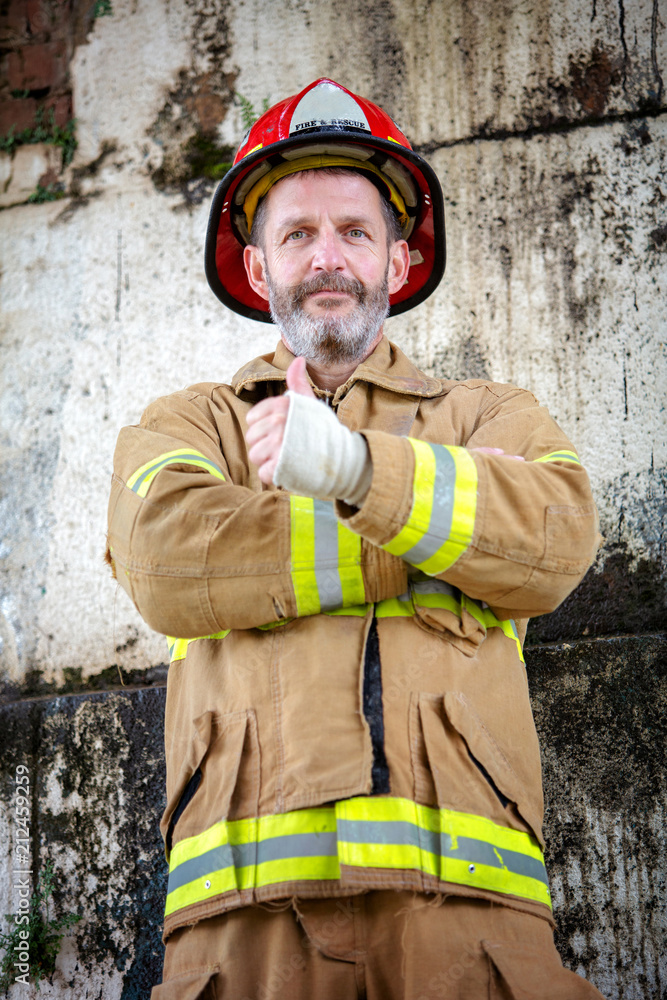 Fototapeta premium handsome fireman in uniform with thumbs up