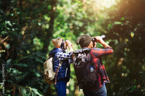 Lovers young with Binoculars and camera in rain Forest, Travel concept, Hiking concept.