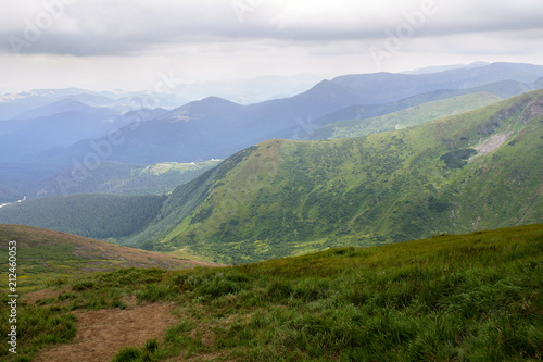 Landscape of mountains with hills and glades with cloudy sky. Carpathian mountains