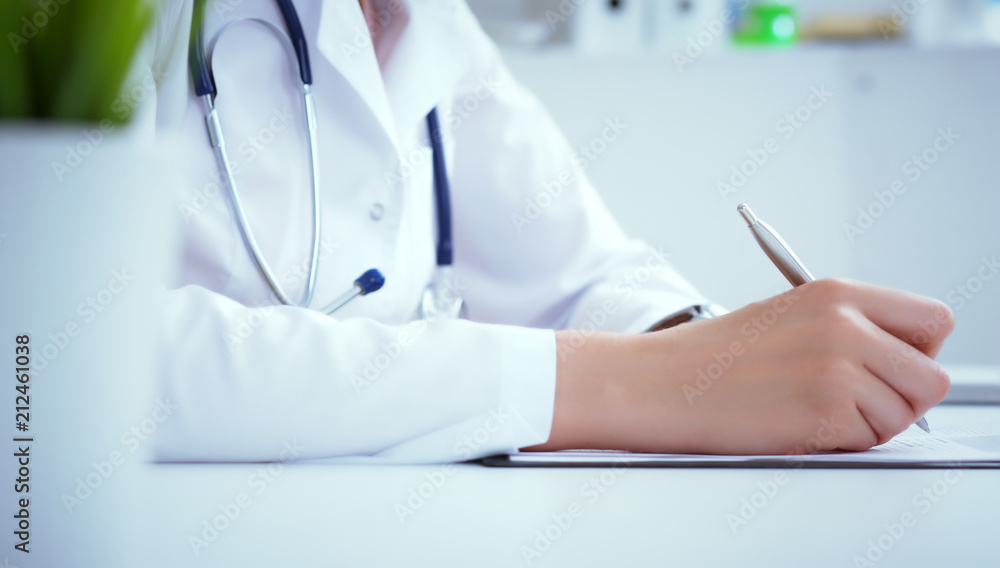 Front view of female doctor holding silver pen filling patient history list at clipboard pad. Physical exam or disease prevention. Front view of female doctor holding silver pen filling patient history list at clipboard pad. Physical exam or disease prevention.