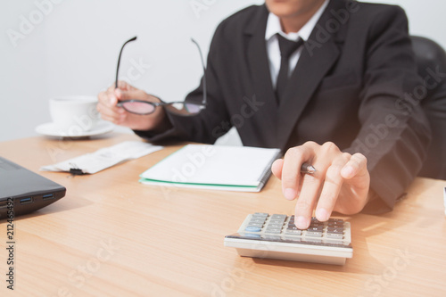 Fotografie Asian man in black suit holding pen writing a tax report lead to liquidation and