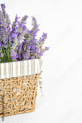 Fototapeta Naklejka Na Ścianę i Meble -  Dettaglio mazzo di lavanda officinale in cestino di vimini su sfondo bianco
