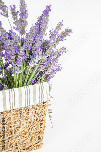 Fototapeta Naklejka Na Ścianę i Meble -  Dettaglio mazzo di lavanda officinale in cestino di vimini su sfondo bianco