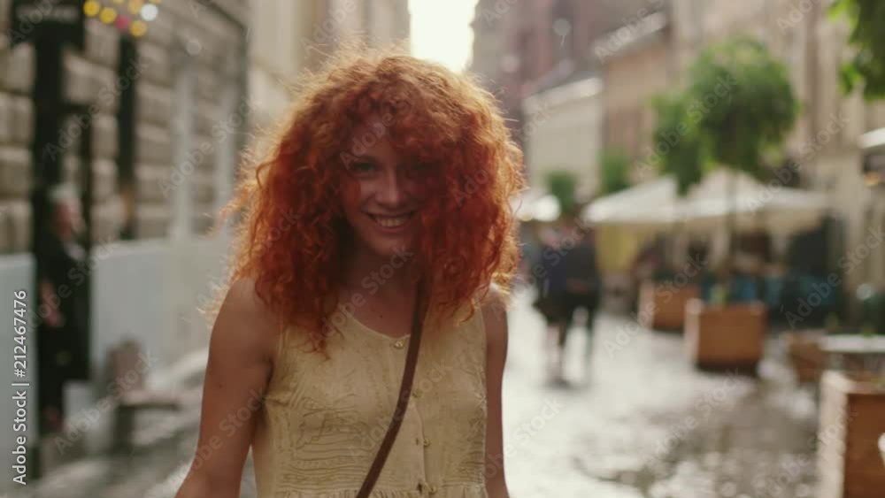 attractive woman with red curly hair walking in the rain on the street look at camera spinning happy smile cute fashion water silhouette summer face female lonely stop close up attractive woman with red curly hair walking in the rain on the street look at camera spinning happy smile cute fashion water silhouette summer face female lonely stop close up